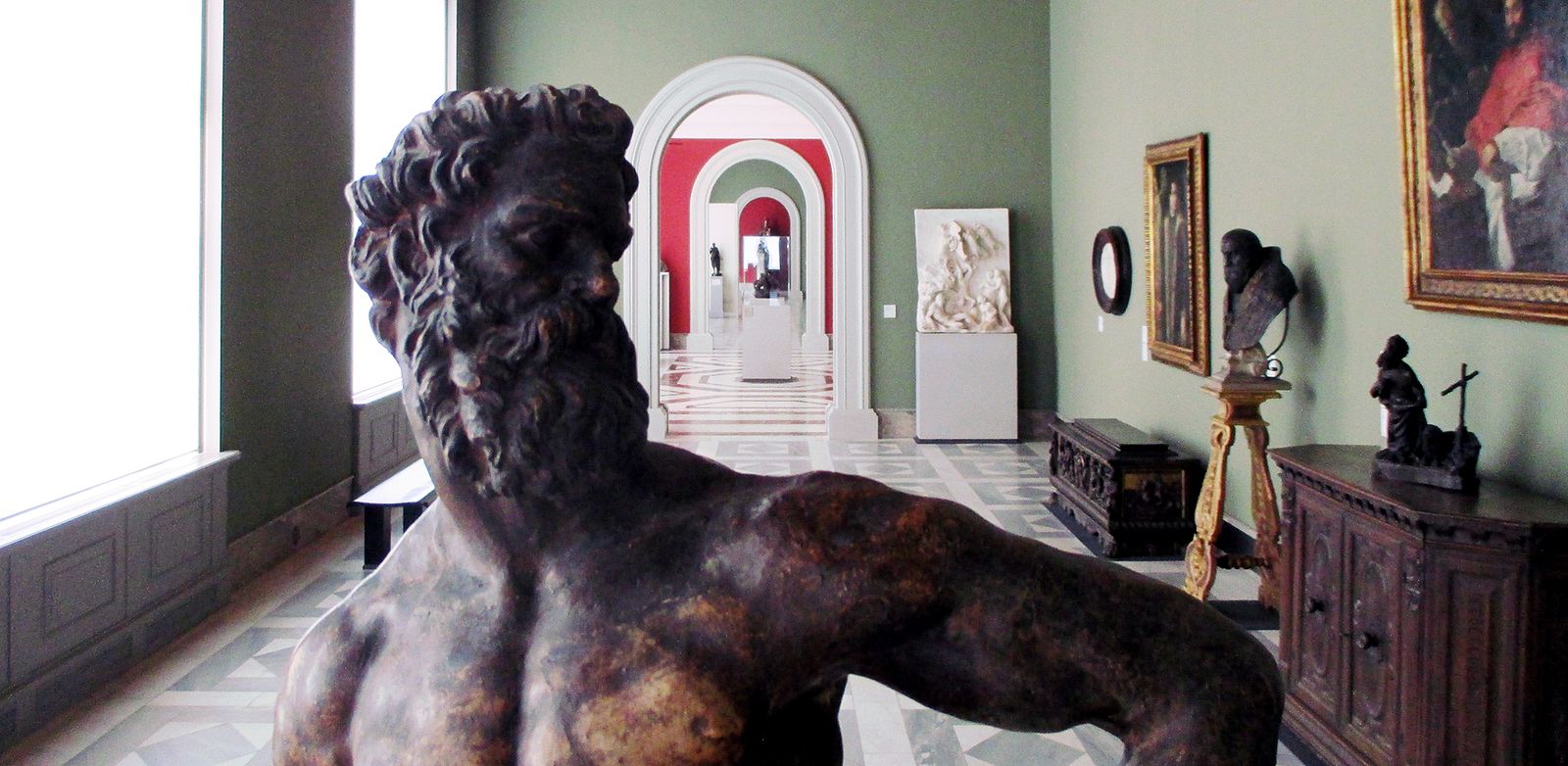 Blick über die Schultern von Giambolognas Herkules (um 1600) im Bode-Museum. Im Hintergrund ist der Abguss der Bronze Johannes des Täufers zu sehen