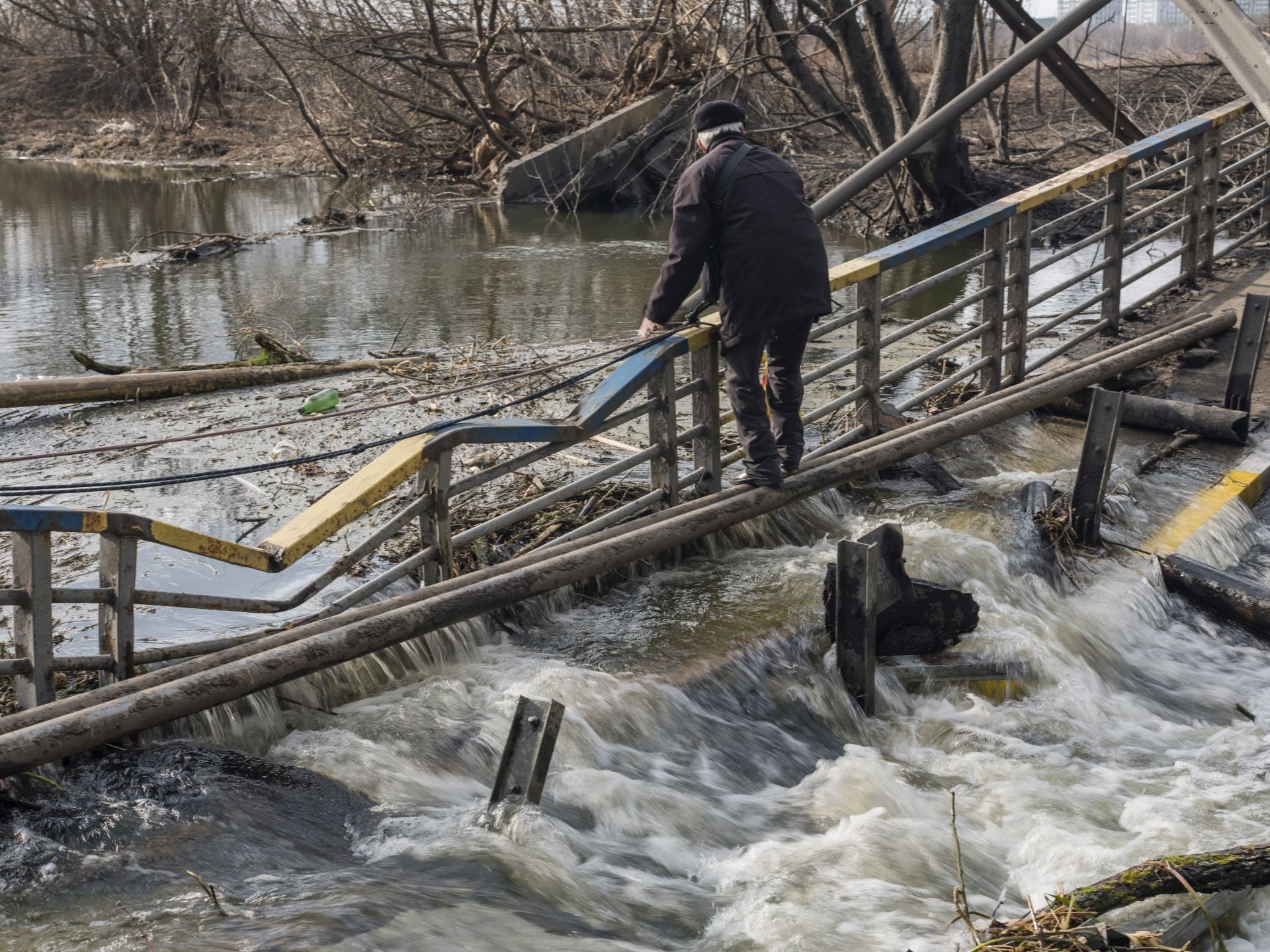 Inhabitants of Irpin cross river under the ruined bridge, which connects Irpin with Kyiv and at the moment is the only escape point from the city. Ukraine 2022. Irpin, 4. März 2022 © Mila Teshaieva