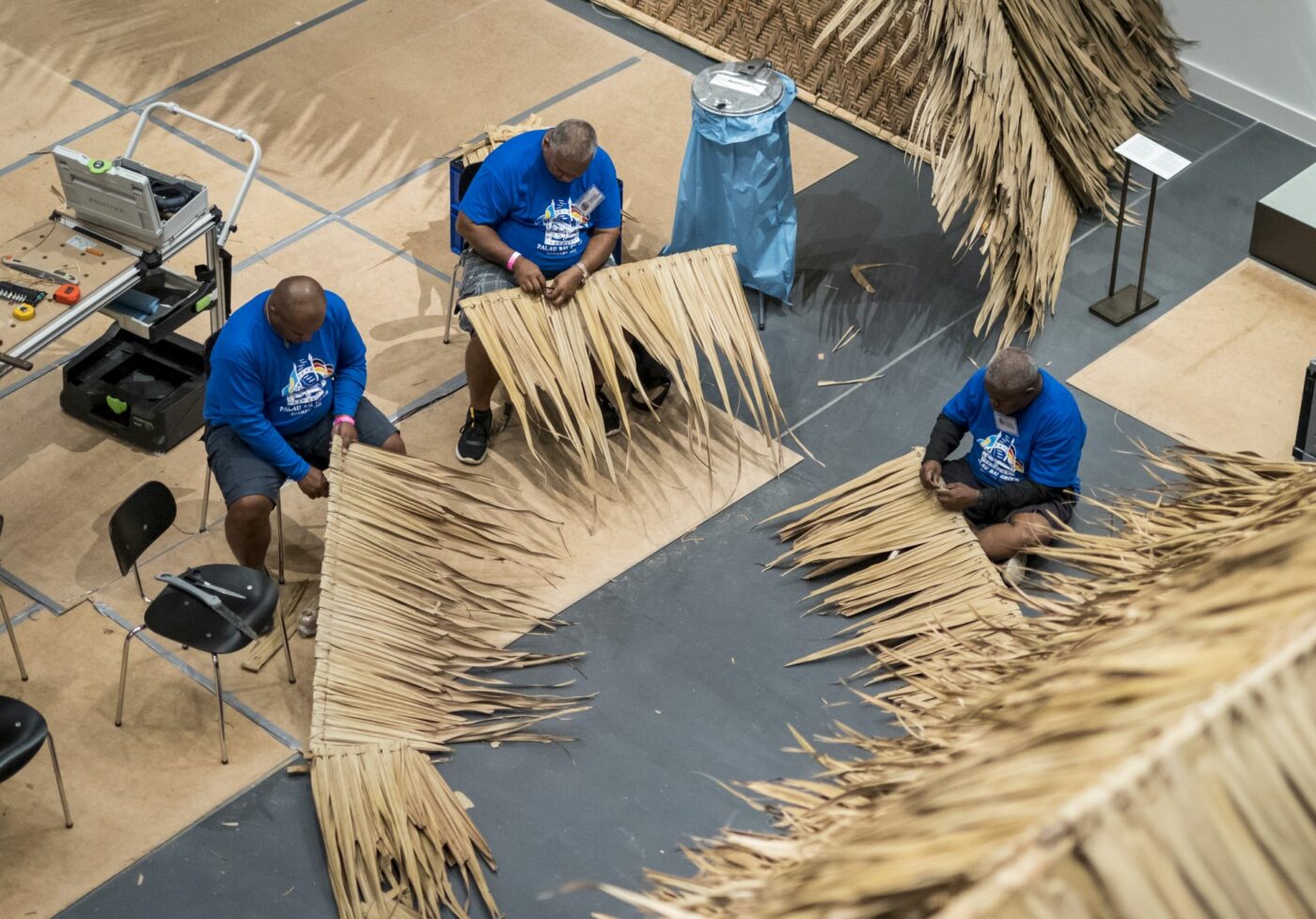 Handwerker von der Insel Palau decken das Dach des Versammlungshauses im Humboldt Forum © SPK / photothek